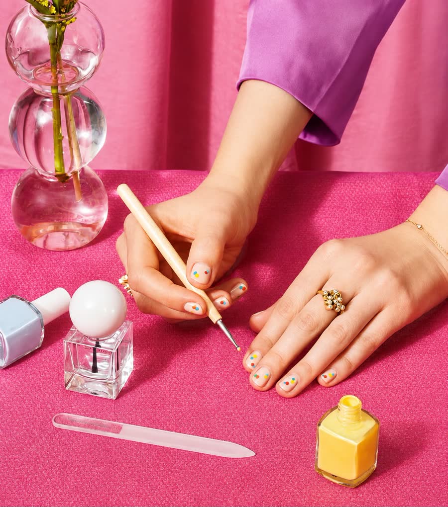 At-home manicure: nail polish bottles and a nail file on a pink background
